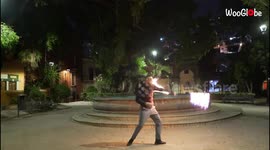 'Fire artist flawlessly juggles a LIT UP Thai Staff '