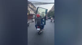Hauling huge glass on a motorcycle is a work of art