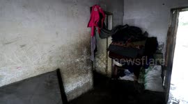 Palestinian woman, sits with her children at their home on a rainy day in Deir Al-Balah camp in the central Gaza Strip