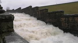 Torrent flows down overflow channel of reservoir near Wardle, UK, during Storm Franklin