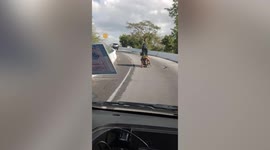 Five kids ride on a single motorcycle in Thailand