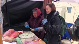 Volunteers stand guard and dish out food at defense checkpoint to protect Kyiv