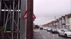 Workmen install road traffic warning sign so it's hidden behind telephone pole in Kent, UK