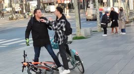 Road rage in Paris between two cyclists fighting on their bikes. Place de la République. 14 march 2022.