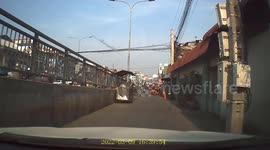 Bungling motorcycle rider gets stuck after turning into one-way road in Cambodia