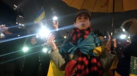 Ukrainians at Trafalgar Square waving phones as torches in remembrance