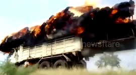 Large bale of dried grass catches fire while being transported on delivery truck
