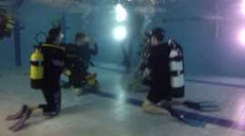 Divers training in a pool doing their `Ocean Diver ` doing exercises, like Mask clearing and Regulator retrieval