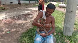 The cure monkey is playing in village field with some other kids and the aged man