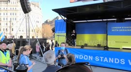 Sadiq Khan stands on a barrier and applauds to Ukrainian supporters at Trafalgar Square