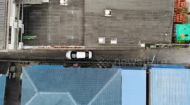 Drivers inch their way through this extremely tight street in Thailand