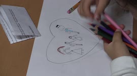 Niña dibujando una familia y coloreandola, girl drawing a family and givein it colour