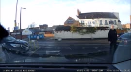 A man walking into a car that has pulled into a parking space in a car park
