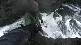 Massive wave knocks local off rock into sea on Iceland's coast