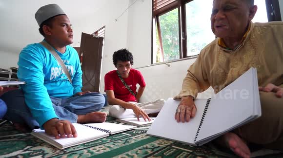 Indonesian Muslims with visual impairments recite Quran written in braille during Ramadan