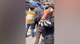 Officers drag away man trying to jump queue at Covid-19 testing site in China