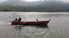 Burmese fishermen sail in wooden long tail motorboats close to Thailand