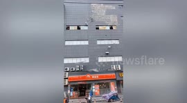Wind causes tiles to peel off building and crash down onto pavement in southern China
