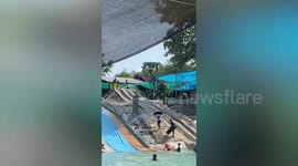 Youngster flies out the of the pool in waterslide fail