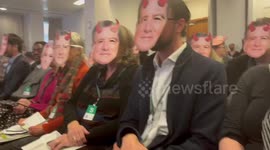 Protesters from Money Rebellion disrupt Standard Chartered Banks AGM wearing masks of the CEO and calling for an end to fossil fuel funding, London, England, UK