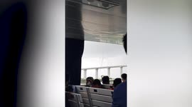Terrified boat passengers watch as waterspout tornado passes nearby bridge