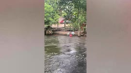 Hard-working dessert vendor sells candies to tourists while drifting through waterfall