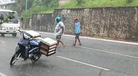 Kind biker helps disabled man cross busy road during heavy rain in the Philippines