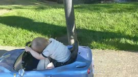 Boy sleeps in toy car