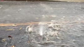 heavy rainfall causes flash flooding, footage of manhole cover being blown off from the water pressure.