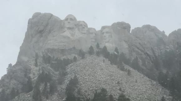 Heavy snow falling at Mount Rushmore as a late season winter storm impacts parts of South Dakota