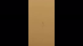 Fisherman floats in Tigris River during sandstorm