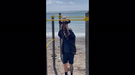 'This little fitness freak can hang from a pull-up bar on his own! '