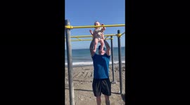 'STRONG baby boi flexes his unrivaled grip by hanging from a pull-up bar'