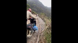 Funny moment when two women try to move their motorbike over a slope but fail.