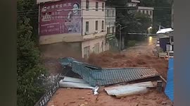Muddy floodwater gushes onto street, destroying warehouses and shops in southern China