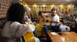 Palestinians choose musical instruments before buy its inside a music store