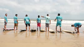 alestinian surfers ride a wave on the shore of the Mediterranean, in Gaza city