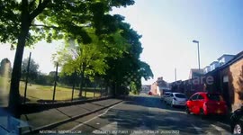 Young female driver drives the wrong way around a roundabout narrowly avoiding a collision