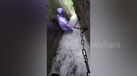 Tourists struggle to descend as rapid water cascades down stairs at China's Mount Hua