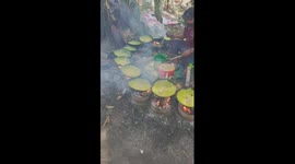 Two old chefs demonstrate their skill in pouring pancakes with more than 10 pans