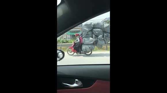 Motorcyclist defies physics as they transport huge load on vehicle