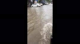 College students wade through flooded streets as heavy rain unleashed on Mumbai