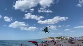 Russian military helicopter makes low pass over Crimean beach