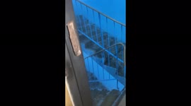 Burst drainpipe after heavy rain leads to waterfall on staircase in Minsk property