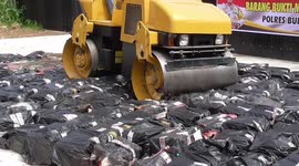 Indonesian police use STEAMROLLER to destroy thousands of unlicensed bottles of liquor