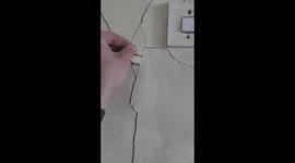 Laughter in the dark: Ukrainian man jokes about fixing wall of destroyed home