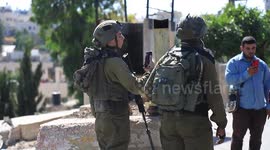 Israeli forces move the iron gate inside the town of Beit Ummar, north of Hebron, at a distance of 150 meters
