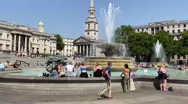 People cool down at the fountains in Trafalgar Square as scorching temperatures hot the UK.