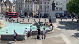 People cool down at the fountains in Trafalgar Square as scorching temperatures hot the UK.