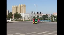 People dress up as traffic lights to direct traffic after real signals break